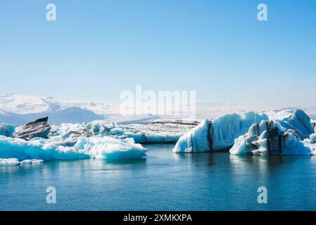 Laguna del ghiacciaio di Jokulsarlon con Iceberg galleggianti e montagne innevate Foto Stock