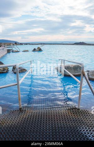 Serena vista della Blue Lagoon Geothermal Spa con corrimano in metallo e rocce Foto Stock