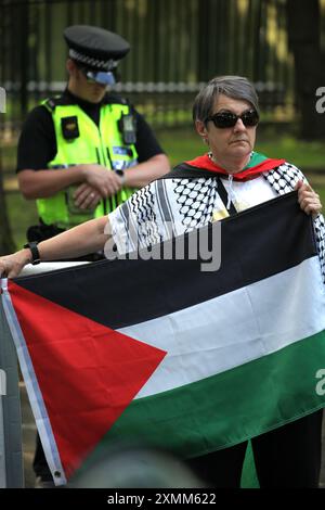 Wakefield, Inghilterra, Regno Unito. 28 luglio 2024. Un manifestante detiene una bandiera palestinese fuori dall'HMP Newhall durante la protesta a sostegno di un collega attivista in custodia cautelare. L'attivista palestinese Francesca è trattenuta in custodia cautelare all'interno. Si dice che abbia causato danni criminali a due banche a Leeds per il gruppo palestinese Palestine Action. Di conseguenza è stata rimandata per tre mesi alla prigione di Newhall, Wakefield. I sostenitori chiedono che venga rilasciata immediatamente su cauzione (Credit Image: © Martin Pope/ZUMA Press Wire) SOLO PER USO EDITORIALE! Non per USO commerciale! Foto Stock