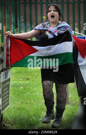 Wakefield, Inghilterra, Regno Unito. 28 luglio 2024. Un manifestante detiene una bandiera palestinese fuori dall'HMP Newhall e canta durante la protesta a sostegno di un collega attivista in custodia cautelare. L'attivista palestinese Francesca è trattenuta in custodia cautelare all'interno. Si dice che abbia causato danni criminali a due banche a Leeds per il gruppo palestinese Palestine Action. Di conseguenza è stata rimandata per tre mesi alla prigione di Newhall, Wakefield. I sostenitori chiedono che venga rilasciata immediatamente su cauzione (Credit Image: © Martin Pope/ZUMA Press Wire) SOLO PER USO EDITORIALE! Non per USO commerciale! Foto Stock