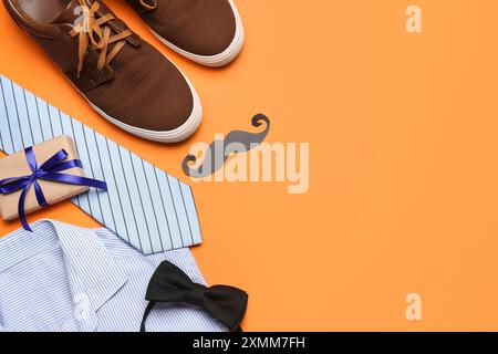 Composizione con scarpe maschio, camicia, accessori e regalo per la festa del papà su sfondo colorato Foto Stock