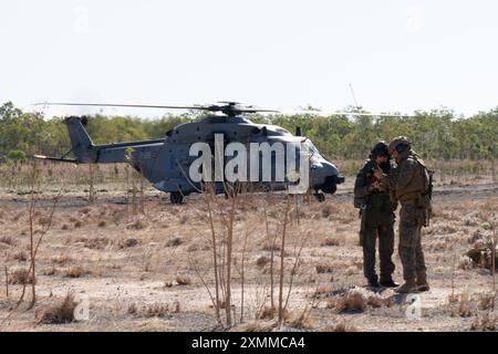 Ryan Ryman, l'ufficiale aereo della Marine Rotational Force – Darwin 24.3, parla con un capo dell'equipaggio dell'elicottero NH-90 della Marina italiana in preparazione di una formazione bilaterale come parte di una sortita di addestramento durante l'esercitazione Pitch Black 24 presso Mount Bundey Training area, NT, Australia, 22 luglio 2024. Exercise Pitch Black 24 è il più grande dei 43 anni di storia dell'esercitazione e riunisce 20 nazioni partecipanti, più di 140 aerei da tutto il mondo e più di 4.000 persone. Exercise Pitch Black 24 consente l'Aviation Combat Element di MRF-D 24.3, Marine Medium Tiltrotor Squa Foto Stock