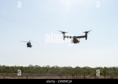 US Marines con Marine Medium Tiltrotor Squadron 268 (rinforzato), Marine Rotational Force – Darwin 24.3, pilotano un MV-22B Osprey insieme ai piloti della Marina italiana su un elicottero NH-90 per una formazione bilaterale come parte di una sortita di addestramento durante l'esercitazione Pitch Black 24 presso Mount Bundey Training area, NT, Australia, 22 luglio 2024. Exercise Pitch Black 24 è il più grande dei 43 anni di storia dell'esercitazione e riunisce 20 nazioni partecipanti, più di 140 aerei da tutto il mondo e più di 4.000 persone. Exercise Pitch Black 24 consente l'Aviation Combat Element di MRF-D 24.3, VMM-268 (R Foto Stock