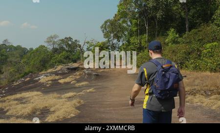 Uomo che cammina lungo il sentiero attraverso la foresta, esplora la natura e divertiti Foto Stock