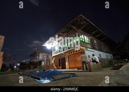 Giornalisti che hanno una conversazione con un proprietario di una casa in un quartiere residenziale costruito in stile architettonico tradizionale malese, a Liwa, provincia di Lampung, Indonesia. Foto Stock