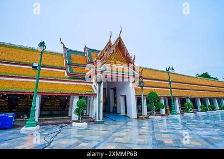 La vista sulla galleria coperta e l'ingresso principale al Tempio di Wat Suthat, Bangkok, Thailandia Foto Stock