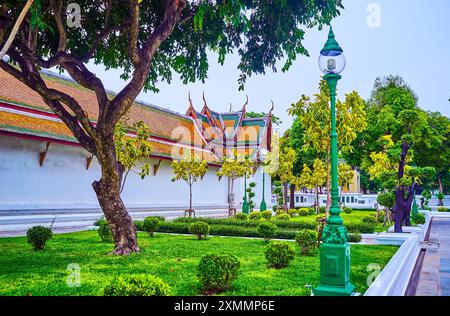 Il cortile del Tempio Wat Suthat e un piccolo giardino con alberi, Bangkok, Thailandia Foto Stock