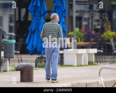 Cherso, Croazia - 25 ottobre 2022: Un uomo di mezza età che cammina da solo in città cherso in una giornata nuvolosa Foto Stock