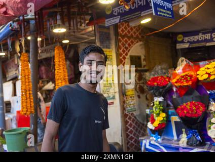 Uomo del Bangladesh che vende fiori di ghirlanda al mercato dei fiori, Divisione di Dacca, Dacca, Bangladesh Foto Stock