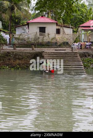 Donna bengalese che lavava piatti da cucina in un fiume a Sundarbans, Barisal Division, Banaripara, Bangladesh Foto Stock