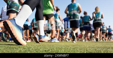 L'inizio di una gara di corsa, un grande gruppo di corridori. Corsa, immagine iconica. Blocca l'azione in primo piano di scarpe da running e gambe in azione Foto Stock