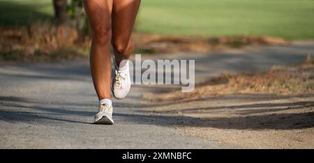 Giovane donna fitness gambe, corsa nel parco pubblico della città di mattina Foto Stock