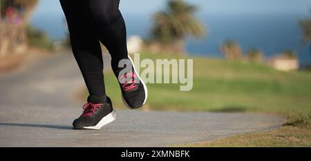 Giovane donna fitness gambe, corsa nel parco pubblico della città di mattina Foto Stock