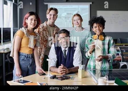 Ritratto di gruppo di un insegnante maturo di educazione ambientale e di studenti multietnici che posa per la macchina fotografica durante la lezione Foto Stock