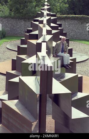 Lo scultore Sir Anthony caro siede sulla sua creazione monolitica lunga 120 metri Goodwood Steps presso la Sculpture del parco di sculture Goodwood vicino a Chichester West Sussex Inghilterra Regno Unito è la scultura più grande della Gran Bretagna. 1 settembre 1996 foto di Roger Bamber Foto Stock