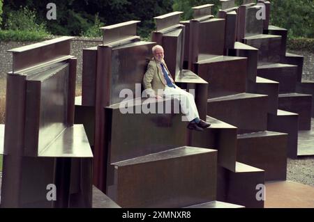 Lo scultore Sir Anthony caro siede sulla sua creazione monolitica lunga 120 metri Goodwood Steps presso la Sculpture del parco di sculture Goodwood vicino a Chichester West Sussex Inghilterra Regno Unito è la scultura più grande della Gran Bretagna. 1 settembre 1996 foto di Roger Bamber Foto Stock