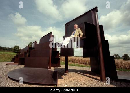 Lo scultore Sir Anthony caro siede sulla sua creazione monolitica lunga 120 metri Goodwood Steps presso la Sculpture del parco di sculture Goodwood vicino a Chichester West Sussex Inghilterra Regno Unito è la scultura più grande della Gran Bretagna. 1 settembre 1996 foto di Roger Bamber Foto Stock