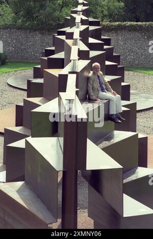 Lo scultore Sir Anthony caro siede sulla sua creazione monolitica lunga 120 metri Goodwood Steps presso la Sculpture del parco di sculture Goodwood vicino a Chichester West Sussex Inghilterra Regno Unito è la scultura più grande della Gran Bretagna. 1 settembre 1996 foto di Roger Bamber Foto Stock