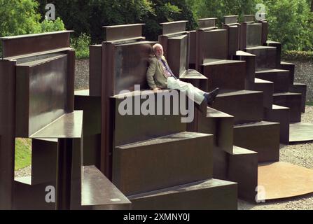 Lo scultore Sir Anthony caro siede sulla sua creazione monolitica lunga 120 metri Goodwood Steps presso la Sculpture del parco di sculture Goodwood vicino a Chichester West Sussex Inghilterra Regno Unito è la scultura più grande della Gran Bretagna. 1 settembre 1996 foto di Roger Bamber Foto Stock