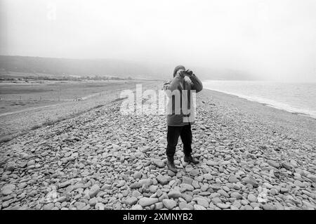 Vista della spiaggia di Porlock Bay , Exmoor , Somerset , attraverso binocoli dove gli agricoltori si oppongono al National Trust permettendo al mare di recuperare la sua vecchia costa 11 luglio 1994 Foto Stock