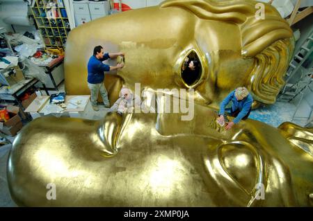 Foto di Roger Bamber :5 febbraio 2007: Lo scultore Aden Hynes (in camicia blu scuro), lavora su una gigantesca maschera BAFTA scolpita in polistirene, rivestita in fibra di vetro e dorata con foglia d'oro nel suo studio di Laindon, Basildon, Essex. Le due sezioni saranno trasportate separatamente e poi unite sul palco della Royal Opera House, Covent Garden, per gli Orange British Academy Film Awards l'11 febbraio 2007. Gli altri operai nella foto sono sue McLean (in occhiello) Jane Macartney e Jamie Livermoore. Foto Stock