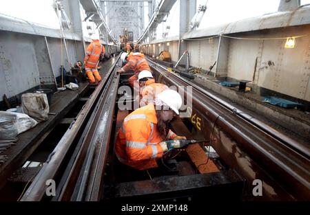 Foto di Roger Bamber: 22 gennaio 2003: Una ristrutturazione da 3 milioni di sterline del Royal Albert Bridge sul Tamar ripristinerà l'originale base in legno duro di Isambard Kingdom Brunel, originariamente utilizzata dalla costruzione nel 1859 fino agli anni 1920 Gli ingegneri hanno scoperto che le traverse moderne e i binari di zavorra causano maggiore affaticamento del metallo alla struttura. Il ponte collega Devon e Cornovaglia. Le immagini mostrano una plater che perfora i supporti in legno duro Ekki per il nuovo cingolo. Foto Stock