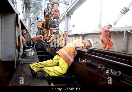 Foto di Roger Bamber: 22 gennaio 2003: Una ristrutturazione da 3 milioni di sterline del Royal Albert Bridge sul Tamar ripristinerà l'originale base in legno duro di Isambard Kingdom Brunel, originariamente utilizzata dalla costruzione nel 1859 fino agli anni 1920 Gli ingegneri hanno scoperto che le traverse moderne e i binari di zavorra causano maggiore affaticamento del metallo alla struttura. Il ponte collega Devon e Cornovaglia. L'immagine mostra il controllo dello strato dei cingoli che controlla l'allineamento delle guide appena posate sul ponte. Foto Stock