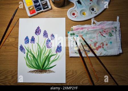 Un'invitante area di lavoro dell'artista caratterizzata da un vivace acquerello di fiori in corso. Illustrazione, creatività, tecniche artistiche, artistiche. Foto Stock