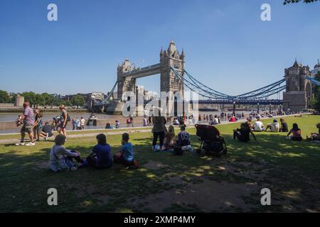 Londra, Regno Unito. 29 luglio 2024. Persone che si rilassano al sole caldo nei campi di Potters vicino al lungofiume di Londra. I funzionari sanitari del Regno Unito hanno emesso avvertimenti gialli per Londra e il sud-est dell'Inghilterra, poiché si prevede che un'ondata di caldo spinga le temperature al di sopra dei 30C credito: Amer Ghazzal/Alamy Live News Foto Stock