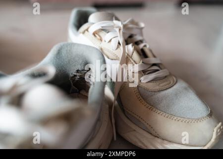 Primo piano di sneakers ben usate, che mettono in risalto l'usura, rappresentando la tendenza principale del sottoconsumo incentrata sulla sostenibilità e sulla consapevolezza Foto Stock