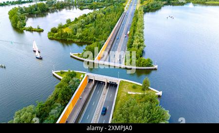 Una vista aerea dell'Aquaduct Veluwemeer nei Paesi Bassi, che mostra l'autostrada sott'acqua per creare due strade di traffico separate, con barche a vela che passano sotto. Foto Stock