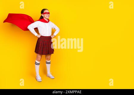 Foto a tutto il corpo di una studentessa adolescente diligente costume da supereroe vestito elegante uniforme isolata su sfondo giallo Foto Stock