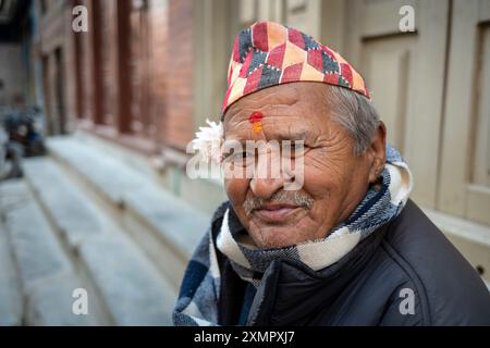 Gentiluomo nepalese che indossa il tradizionale cappello o cappellino di topi dhaka nelle strade di Thimi, Kathmandu, Nepal. Foto Stock