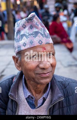 Gentiluomo nepalese che indossa il tradizionale cappello o cappellino topi di dhaka nelle strade di Kathmandu, Nepal. Foto Stock
