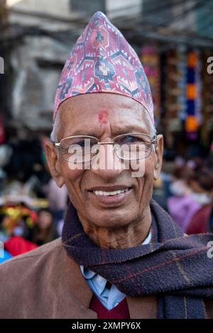 Gentiluomo nepalese che indossa il tradizionale cappello o cappellino topi di dhaka nelle strade di Kathmandu, Nepal. Foto Stock