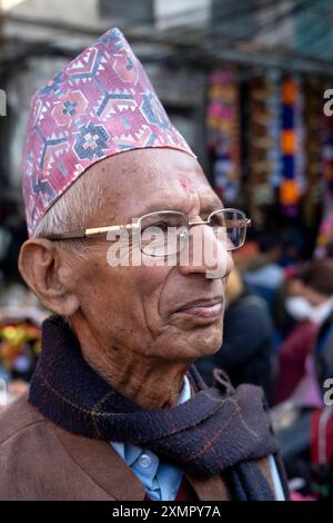 Gentiluomo nepalese che indossa il tradizionale cappello o cappellino topi di dhaka nelle strade di Kathmandu, Nepal. Foto Stock