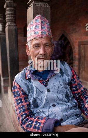 Gentiluomo nepalese che indossa il tradizionale cappello o cappellino topi di dhaka nelle strade di Kathmandu, Nepal. Foto Stock