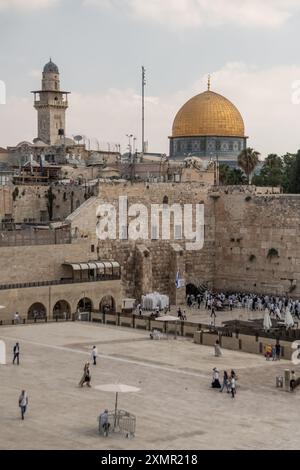 Adoratori ebrei e turisti nella zona del muro Occidentale. Il muro Occidentale, noto anche come muro del pianto in Occidente e muro di al Buraq nell'Islam, è una destinazione di pellegrinaggio per i credenti ebrei. Situato nella città vecchia di Gerusalemme, è una parte del muro di contenimento del Monte del Tempio. Una partizione di metallo divide l'area in due: Uomini a sinistra e donne a destra. Durante tutto il giorno, gli ebrei credenti visitano il sito per pregare, per leggere i libri sacri della Torah e per lasciare un biglietto di carta all'interno delle fessure del muro. L'intera area è sorvegliata da soldati israeliani. Foto Stock