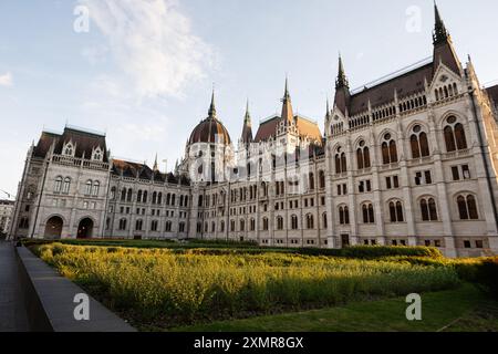 Immagine grandangolare dello storico edificio del parlamento e del giardino adiacente durante il tramonto, che mostra la grandezza architettonica. Foto Stock