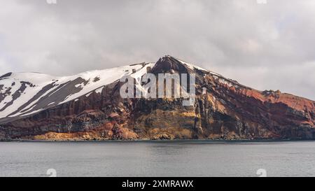 Antartide Colorful Mountain Deception Island Rugged Cliffs Snow Covered Glacier View dalla nave da crociera Ocean. Giorno di sole Fotografia paesaggio natura Foto Stock