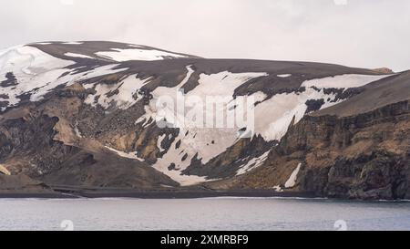 Antartide Penguin Colony Deception Island Rugged Cliffs Snow Covered Glacier View dalla nave da crociera Ocean. Vista panoramica di Sunny Day Landscape Foto Stock