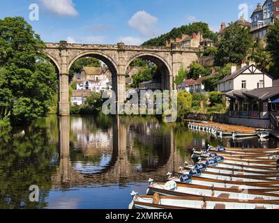 Guardando lungo la linea di barche a remi ormeggiate che costeggiano il fiume verso il viadotto di Knaresborough nello Yorkshire. Foto Stock