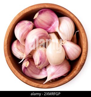 Spicchi d'aglio freschi non sbucciati in un recipiente in legno rustico isolato su bianco. Vista dall'alto. Foto Stock