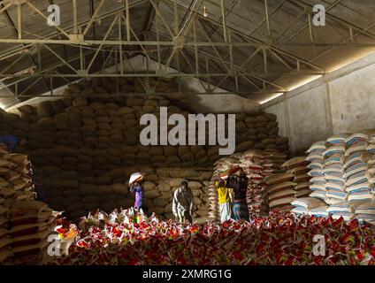 Uomini del Bangladesh che trasportano borse in un magazzino di riso, divisione Chittagong, Ashuganj, Bangladesh Foto Stock