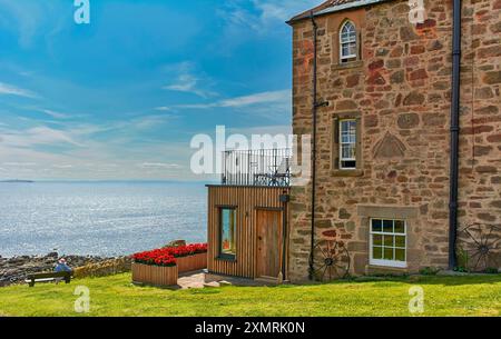 Crail Fife Scozia cielo blu sopra la rinnovata Watch House con fiori colorati Foto Stock