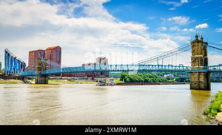 Le chiatte vanno sotto il ponte Roebling a Cincinnati, Ohio Foto Stock