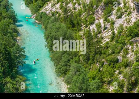 Un gruppo di kayak naviga nelle vibranti acque turchesi del fiume Soca in Slovenia Foto Stock
