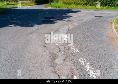 Buche su una strada del Regno Unito, danni da Pothole Foto Stock