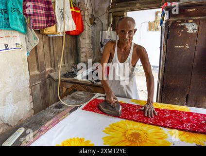 Vecchio bangladeshi che stirava in un piccolo negozio, Rajshahi Division, Puthia, Bangladesh Foto Stock