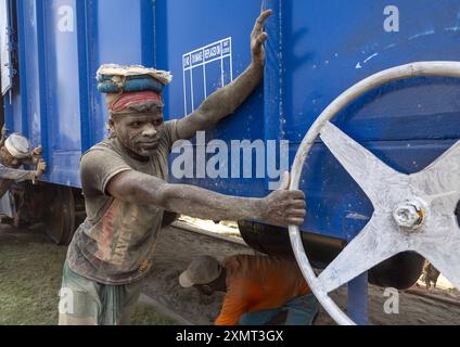 Lavoratori del Bangladesh che spingono un treno blu, divisione Khulna, Abhaynagar, Bangladesh Foto Stock